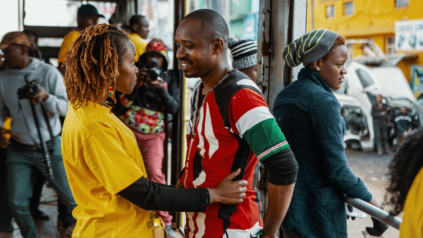 A woman faces a man while placing her hands on his waist. | From "POV: Softie"