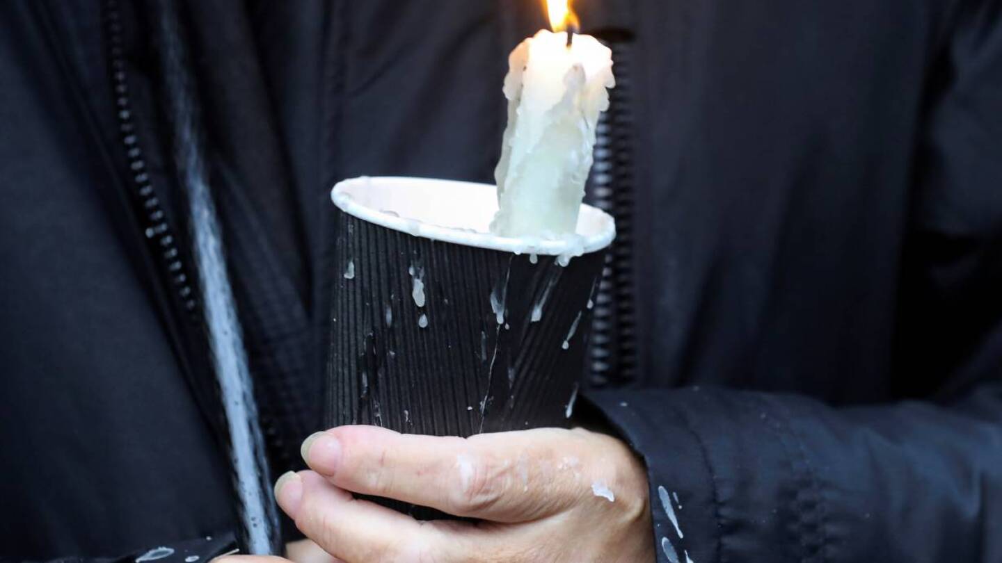 A mourner holds a candle outside St Eugene's Cathedral in Londonderry, Northern Ireland August 4, 2020. | REUTERS/Lorraine O'Sullivan