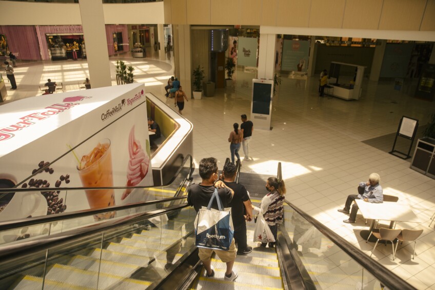 View of an indoor shopping center from the stop of electric stairs.