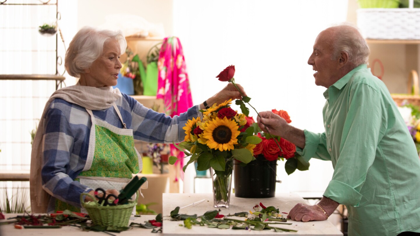 A woman takes a rose off a man's hand.