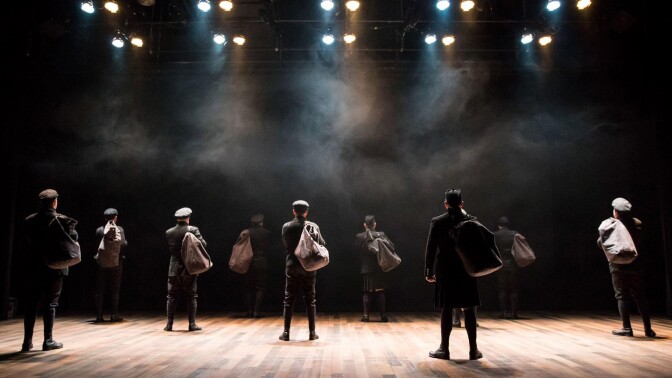 Performers haul sacks over their shoulders on stage. | From "All is Calm: The Christmas Truce of 1914"