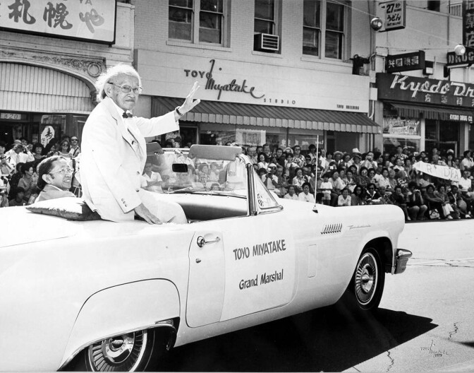 Toyo Miyatake waving the crowd while Archie Miyatake drives during the 1979 Nisei Week Parade