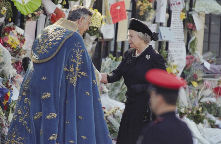 Queen Elizabeth II stands in front of a collection of flower bouquets and handwritten messages at the funeral service for Diana, Princess of Wales at Westminster Abbey, London, England, September 6,1997.