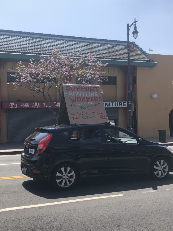 Sign reading, "Support frontline workers" on top of a car, as a part of the rent relief protest in downtown L.A. | Karen Foshay
