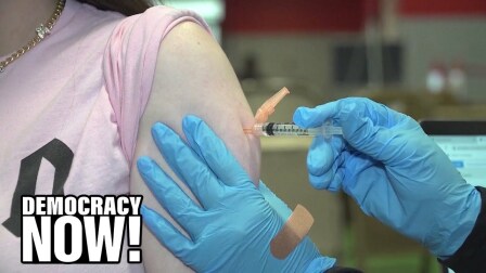 A healthcare worker administers a COVID vaccine shot to a patient's arm.