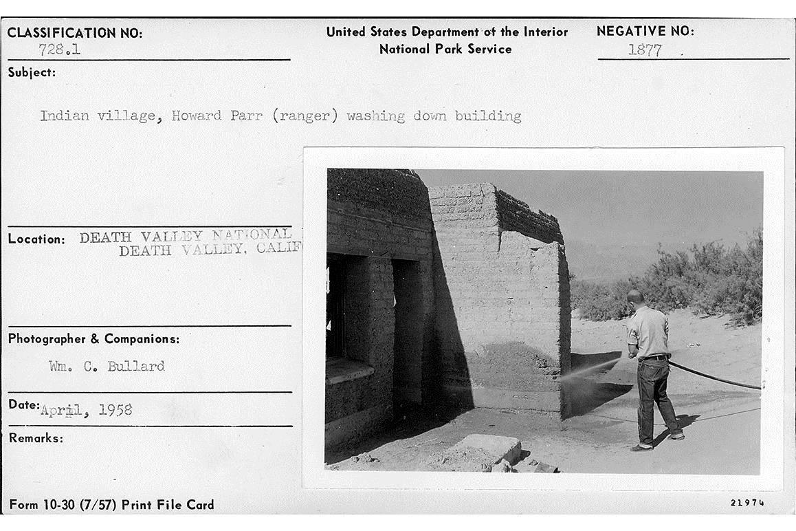 Park Ranger Howard Parr washes down one of the adobe houses
