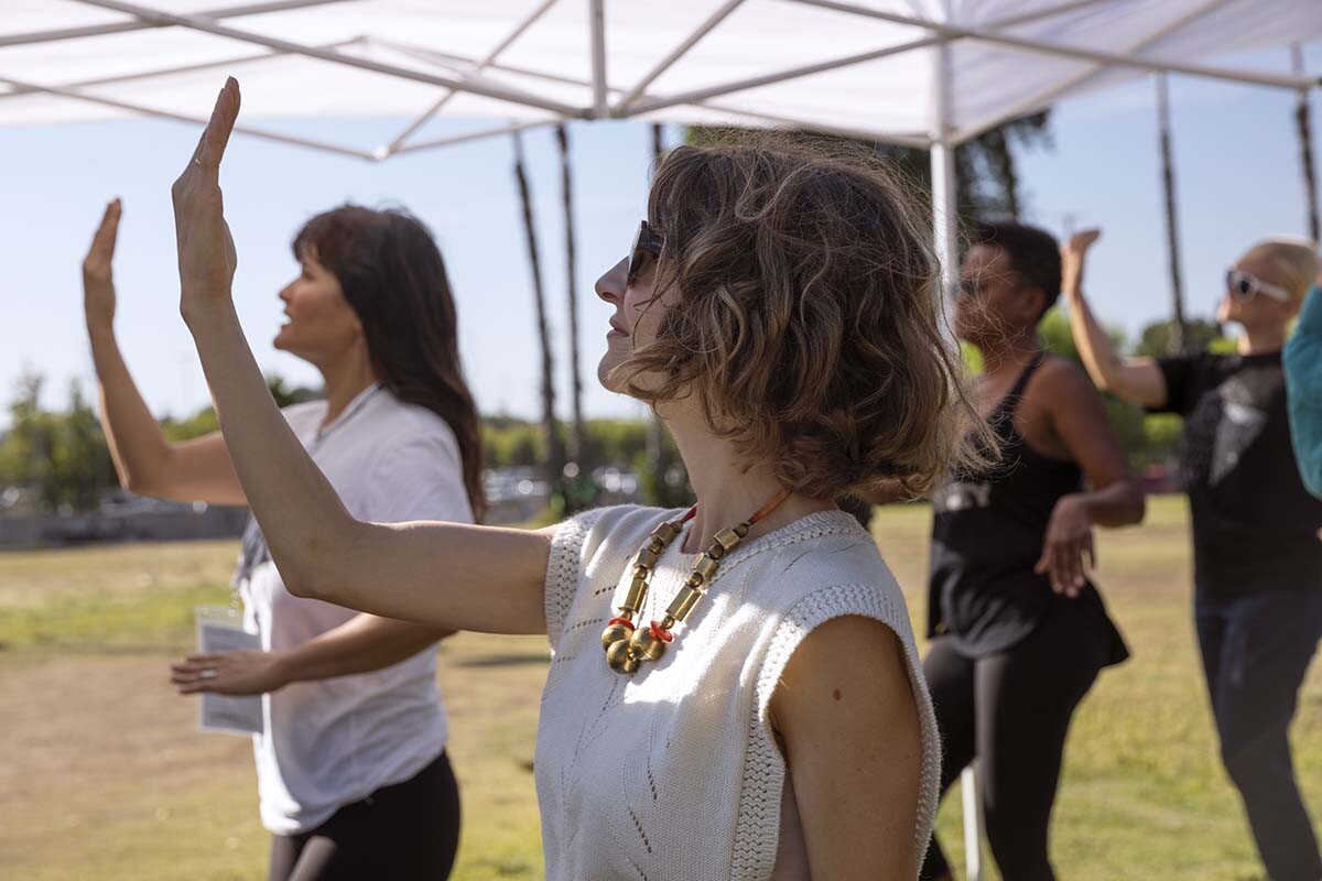 Rehearsals of “ALL AGAIN” by a community chorus show people with raised hands. The event was organized by Carolyn Pennypacker Riggs and Annie Gimas | Courtesy Department of Cultural Affairs, City of Los Angeles