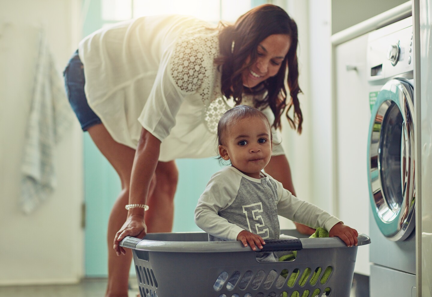 Shot of a mother and her adorable baby boy doing the laundry at home