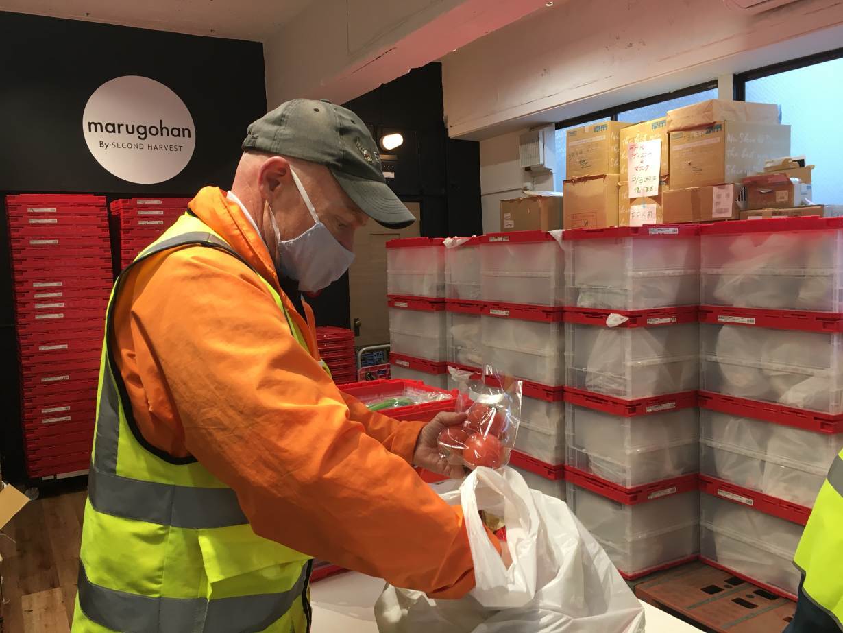 Charles McJilton, founder and CEO of Second Harvest Japan, the country’s biggest food bank, checks the contents of a bag of handouts at one of its food pantries in Tokyo, Japan. February 2, 2021.