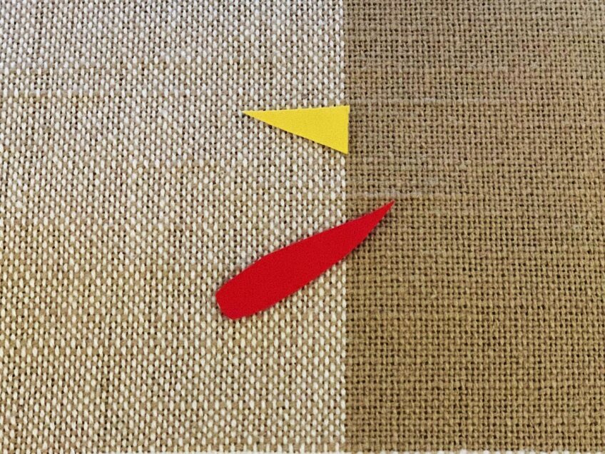 A small yellow triangle and red droplet shape cut out of construction paper to make a mindfulness turkey craft