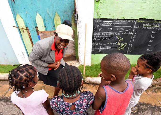 Educator Taneka Mckoy Phipps teaches a lesson with a blackboard painted on a wall, in a low-income neighborhood, during the coronavirus disease (COVID-19) outbreak in Kingston, Jamaica October 27, 2020. October 27, 2020. | REUTERS/Gladstone Taylor