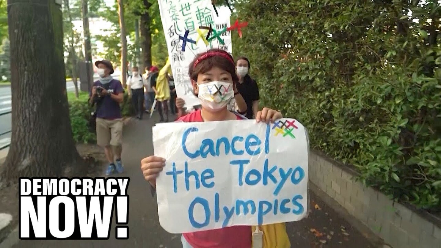 A Japanese protester holds up a sign that reads, "Cancel the Tokyo Olympics."