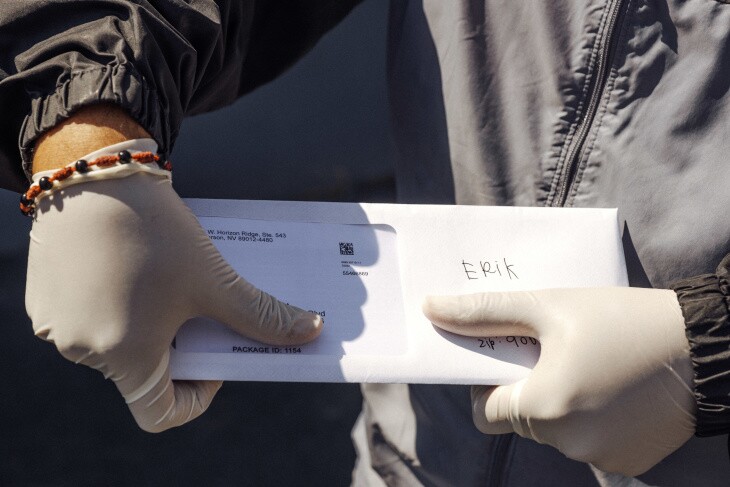 A street vendor holds the envelope with his cash card inside. | Chava Sanchez/LAist