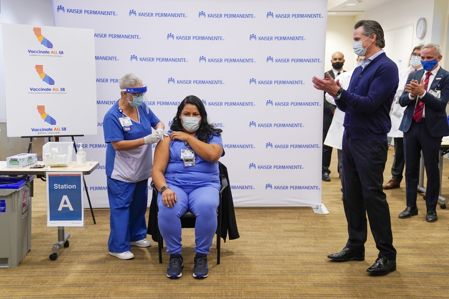 ICU Nurse Helen Cordova, center, receives the Pfizer-BioNTech Covid-19 vaccine as Gavin Newsom, governor of California, applauds at Kaiser Permanente Los Angeles Medical Center in Los Angeles, California, U.S., on Monday, Dec. 14, 2020.