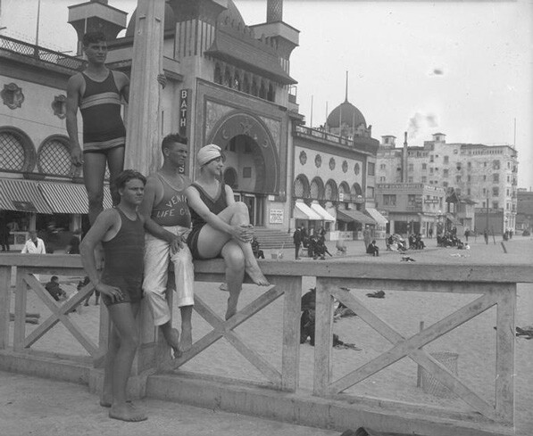 Bathers and a lifeguard on the boardwalk in front of a Venice bath house, circa 1925.