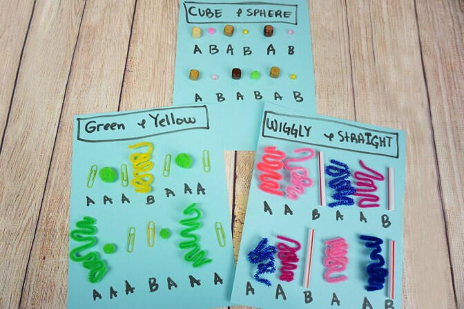 Three pieces of paper with small pipe cleaners arranged in patterns of wiggly and straight pipe cleaners. The third sheet has small cube and sphere shapes arranged in patterns.