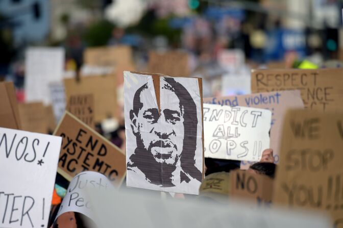 Protesters march holding placards and a portrait of George Floyd during a demonstration against racism and police brutality, in Hollywood, California.