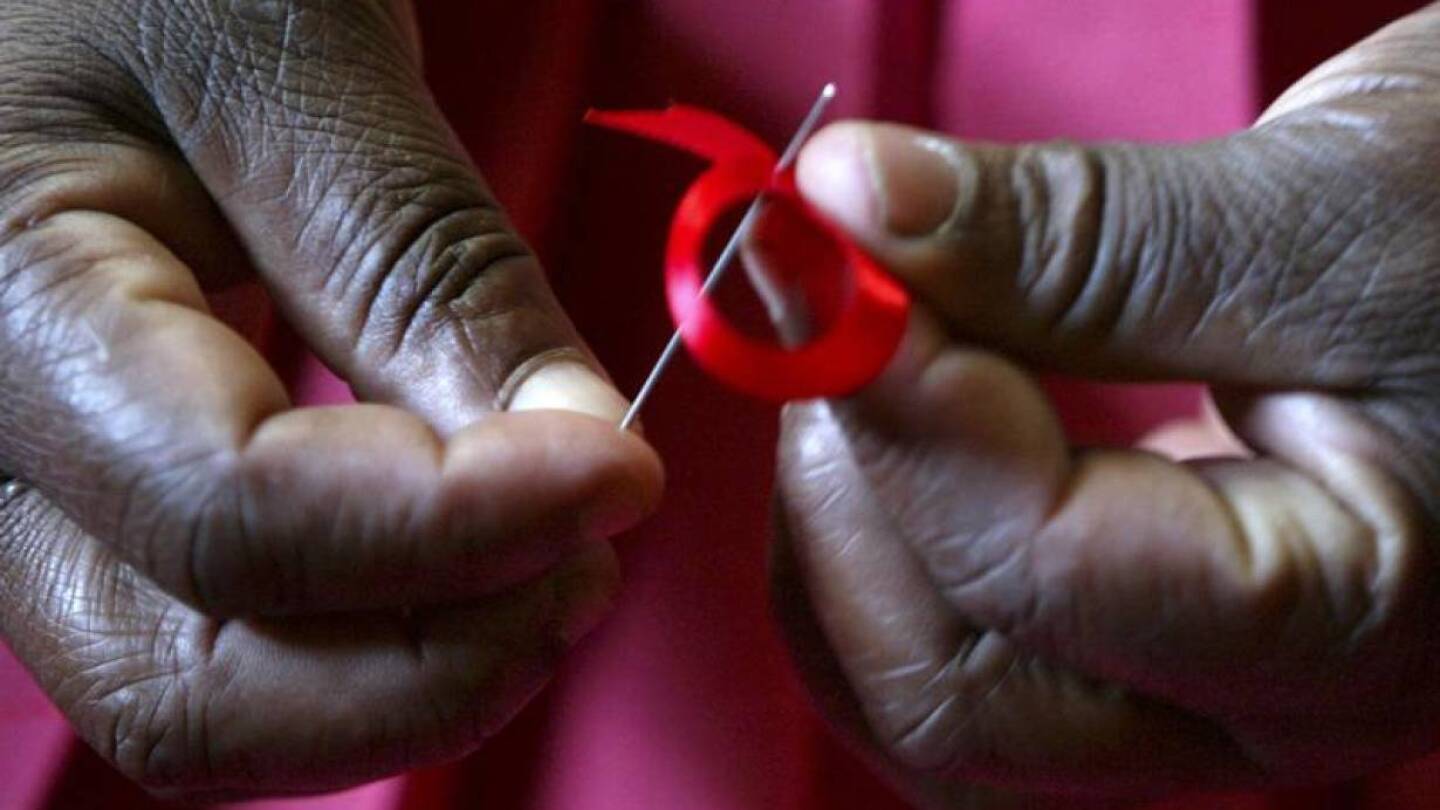 RCHIVE PHOTO: A Kenyan woman prepares ribbons ahead of World Aids Day in Nairobi, November 25, 2004. | REUTERS/Antony Njuguna