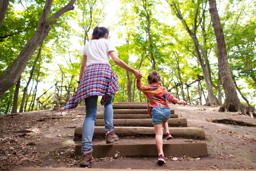 Mother and daughter walking in the forest