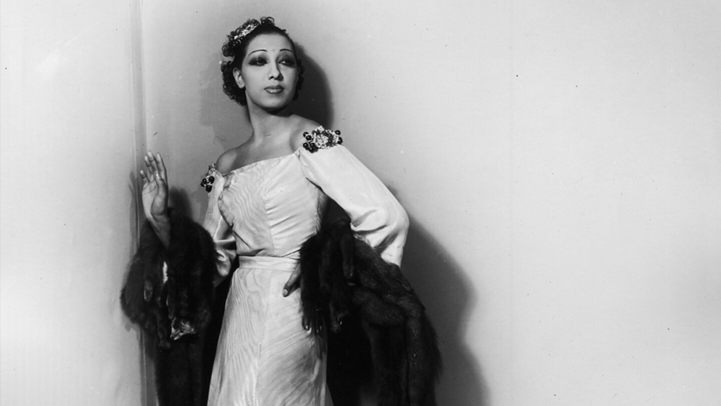 Josephine Baker poses against a wall.