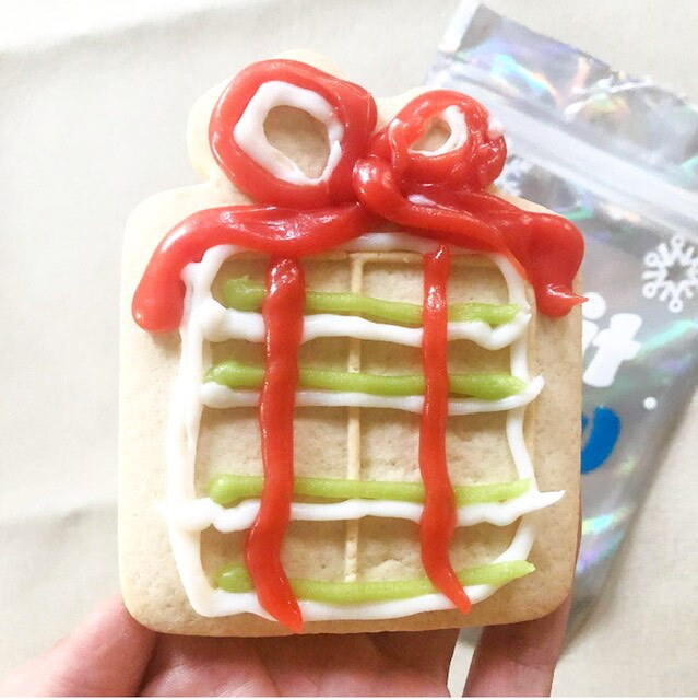 A sugar cookie decorated with colorful icing to look like a present