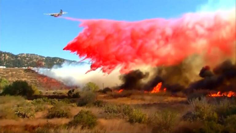 Firefighting plane dropping fire retardant on wildfire in California. | Democracy Now