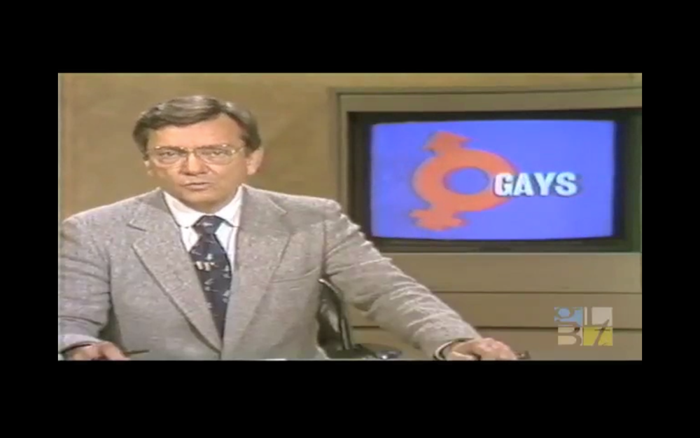 A newscaster with a small screen that says "gays."