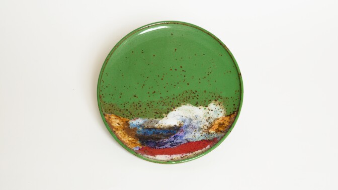 A green plate with a design that looks like a rolling ocean wave.