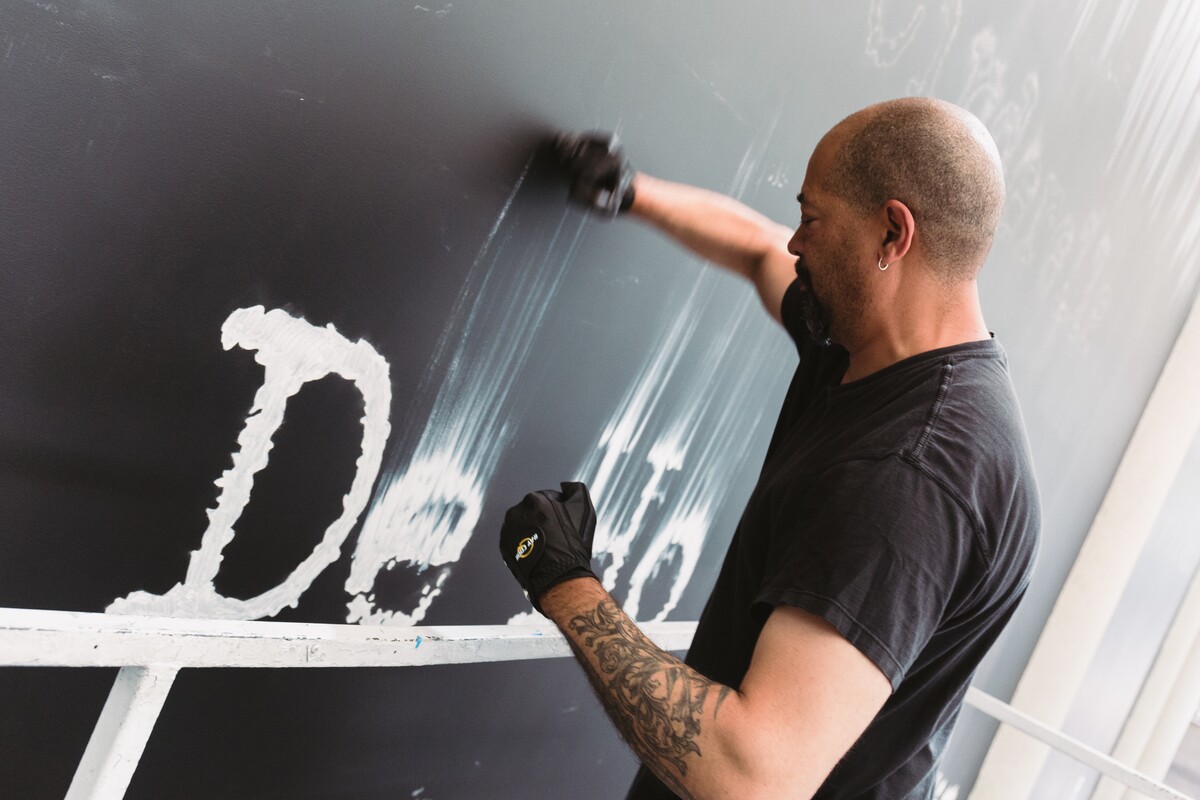 Gary Simmons works on his erasure process for "Gary Simmons: Fade to Black" at the California African American Museum | Tito Molina/HRDWRKER