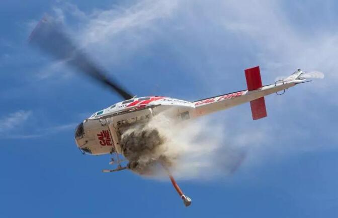 A CAL FIRE helicopter dumps water on a fire. | Courtesy of Cliff Walters