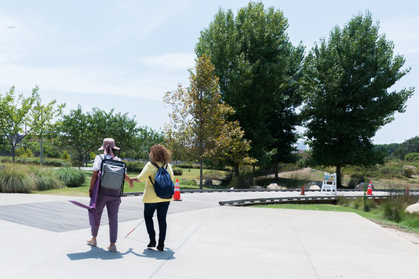 Monica Espinoza, the Immigrants With Disabilities coordinator, guides member Blanca Angulo to a meeting at the Los Angeles State Historic Park. (Heidi de Marco/KHN)