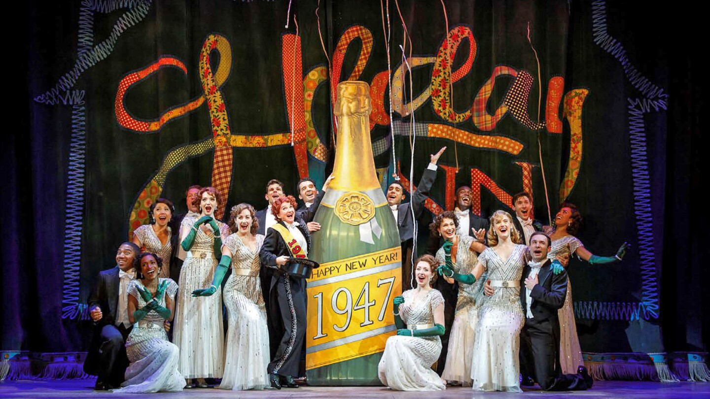 Stage performers gather to pose onstage next to a large cardboard cutout of champagne labeled "Happy New Year: 1947." | "Great Performances: Irving Berlin's Holiday Inn