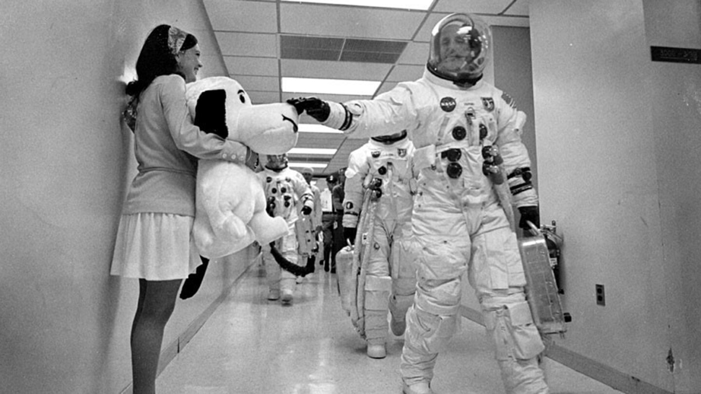 Astronaut Thomas Stafford looks at a banner with Snoopy's image. | NASA
