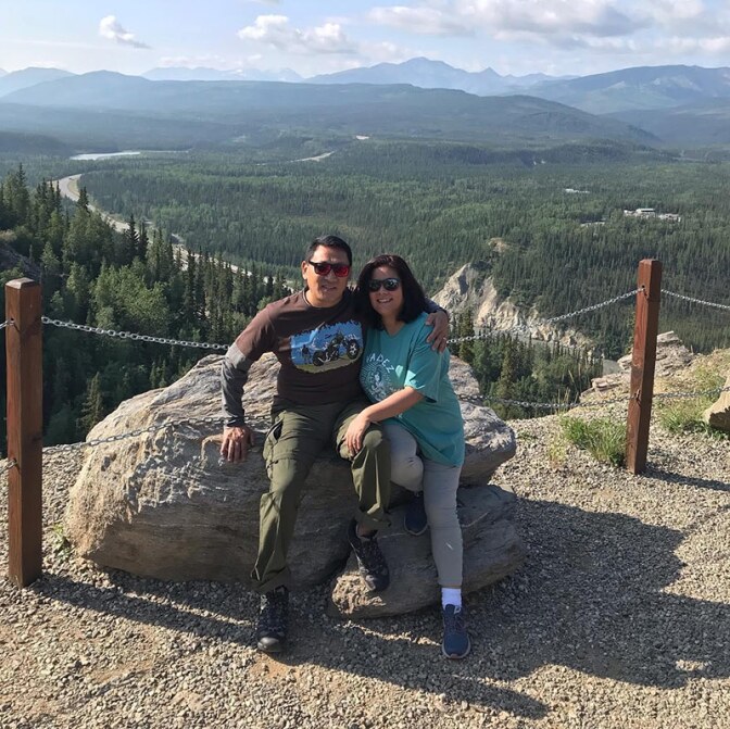 Bijay Bokhim and his wife smile at the camera at the top of a hill during a trip to Alaska. | Courtesy of Bijay Bokhim