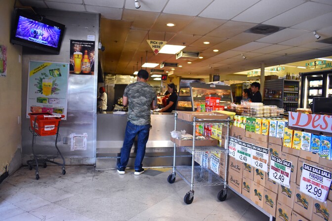 A customer picking up food pre-ordered from the turo-turo section, near the entrance way. | Jacqueline Lee