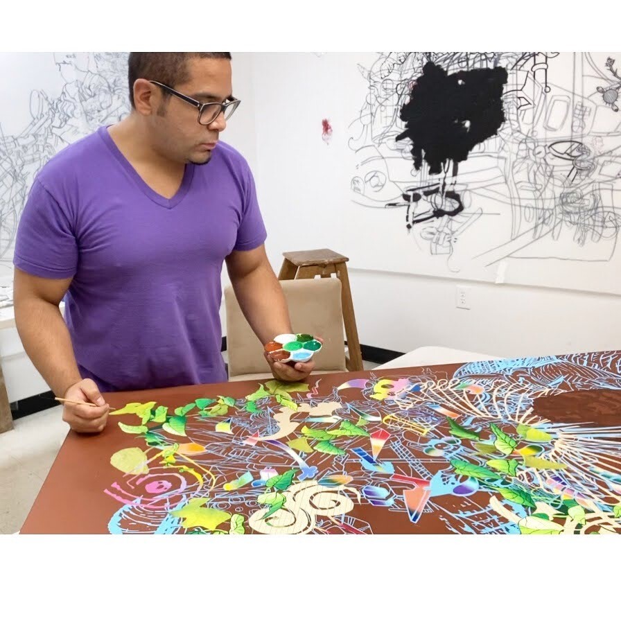 David Rios holds his paint and brush over an abstract piece of art.