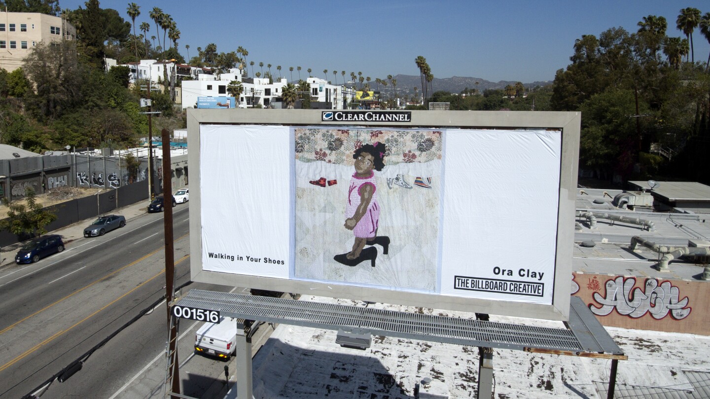 Fiber artist Ora Clay's billboard is located along Sunset Blvd. and shows a young, Black girl in a pink dress wearing a pair of black heels that are too big for her.