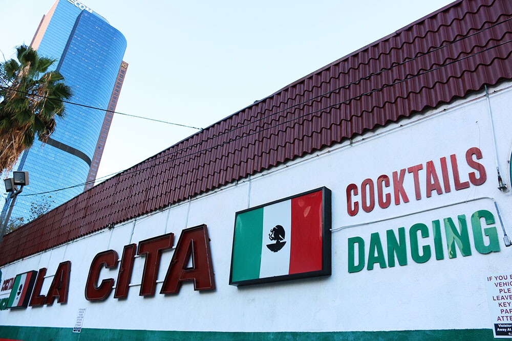La Cita Sign with LA skyscraper in the back: Mexican flag, ":Cocktails," "Dancing"