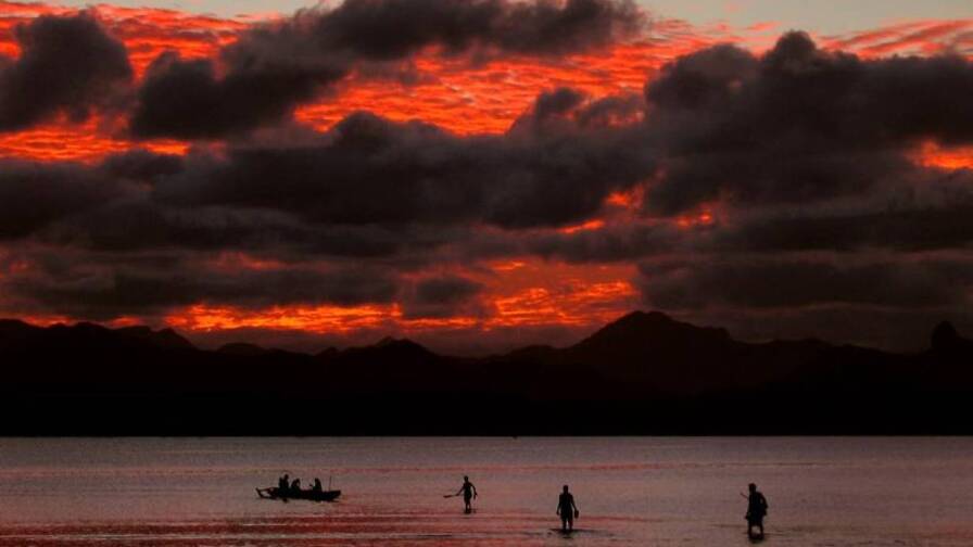 22-cisk3 left"> <p>ARCHIVE PHOTO: Fijian family board their canoe as a sunset lights up the sky behind an island's mountain range in Suva May 1, 2004. | REUTERS/David Gray DG/CP<
