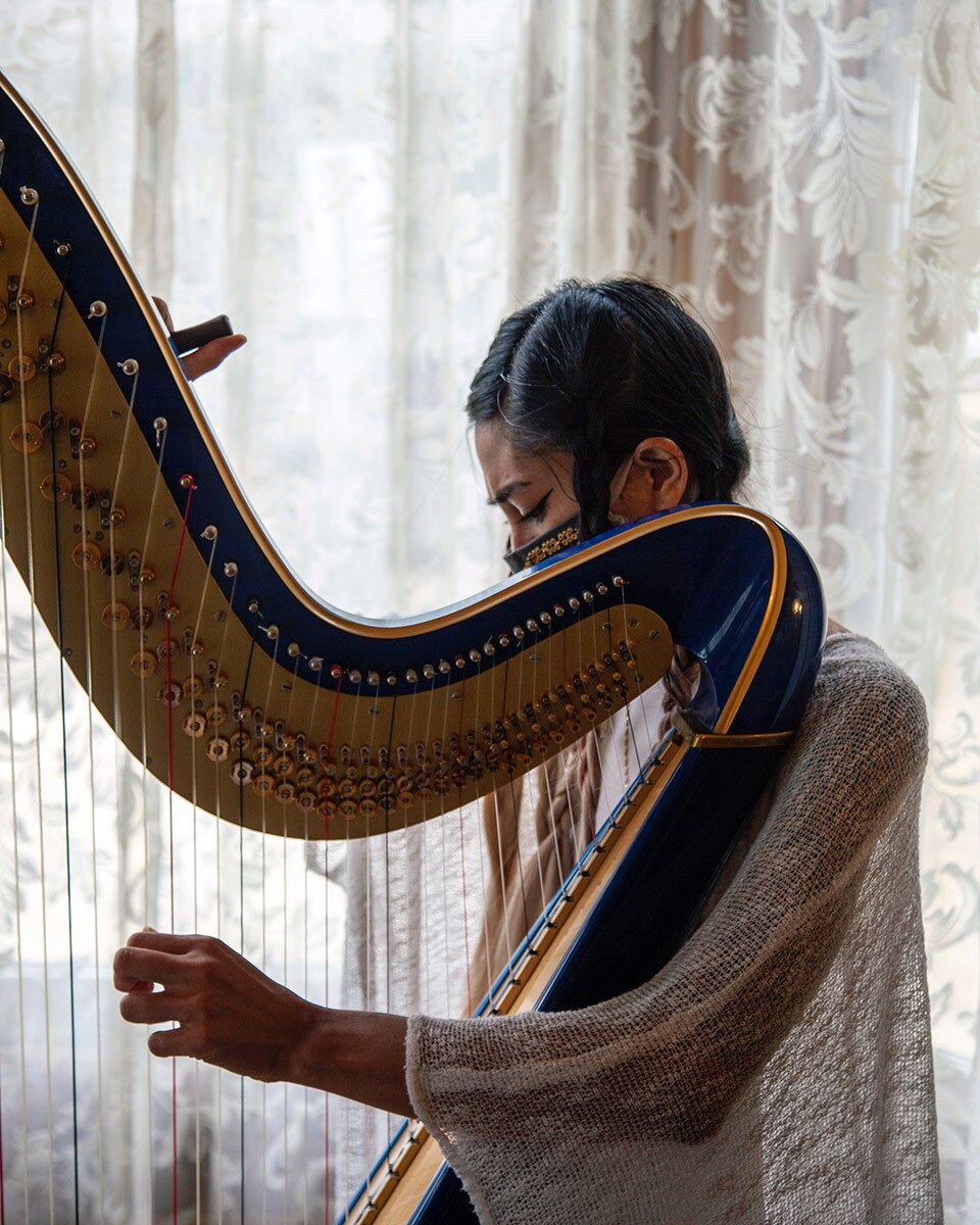 Low Leaf plays her harp inside the Perry House at Heritage Square Museum. | Azul Amaral