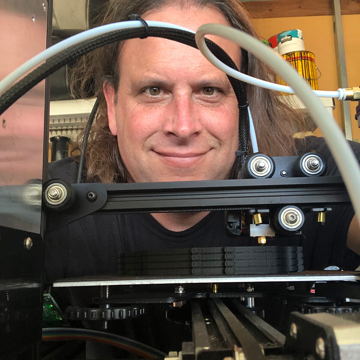 Art professor Ed Giardina smiles from behind a 3D printer. | Courtesy 3D PPE Artist Network