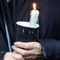A mourner holds a candle outside St Eugene's Cathedral in Londonderry, Northern Ireland August 4, 2020. | REUTERS/Lorraine O'Sullivan
