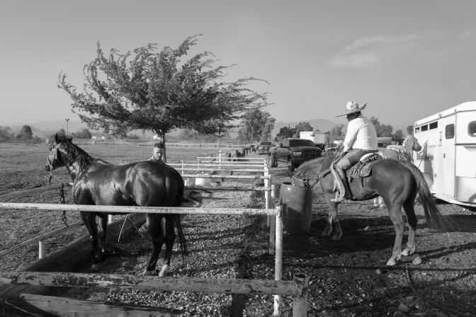 Jóvenes mexicanos con sombreros de ala ancha y muchachos cuidan de sus caballos.