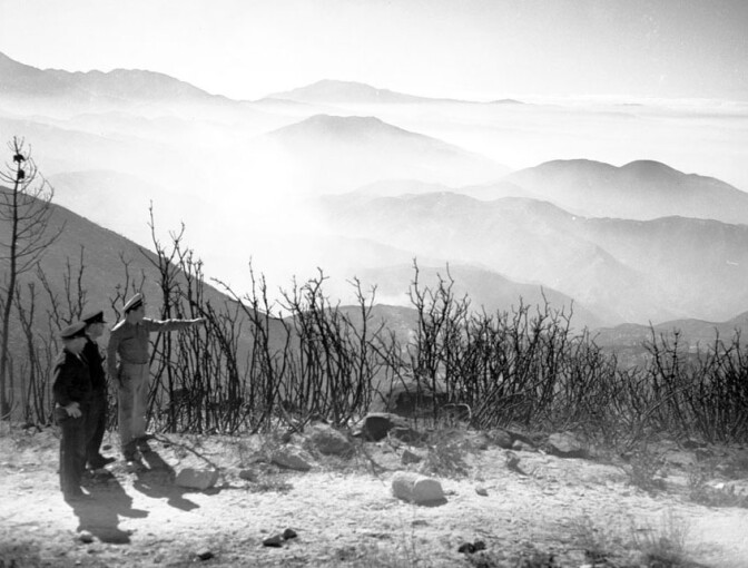 Fire officials observe destruction caused by a wildfire near Lake Arrowhead in 1953. Courtesy of the Los Angeles Examiner Collection, USC Libraries.