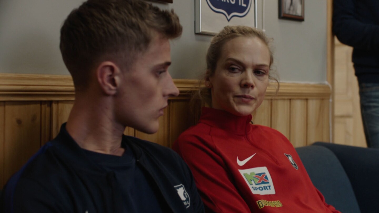 Helena looks at the person sitting next to her. | Still from "Home Ground: Everything for Norway"