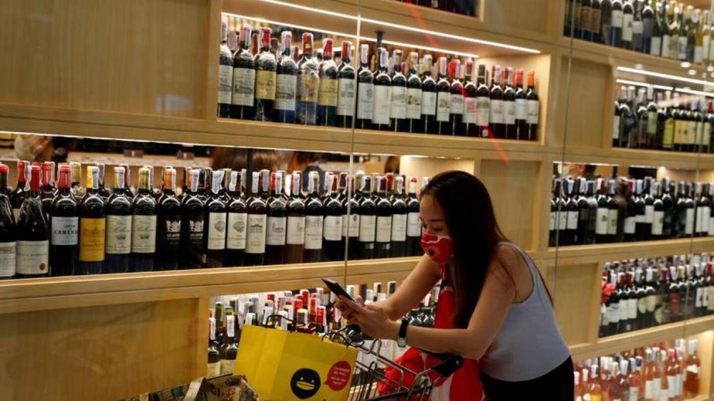 A woman wearing a protective mask is seen at a liquour shop after Bangkok and several other provinces announced a 10-day ban on alcohol sale starting April 10 during the coronavirus disease (COVID-19) outbreak in Bangkok, Thailand, April 9, 2020. REUTERS/