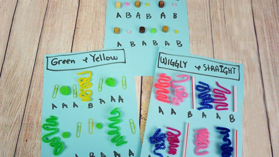 Three pieces of paper with small pipe cleaners arranged in patterns of wiggly and straight pipe cleaners. The third sheet has small cube and sphere shapes arranged in patterns.