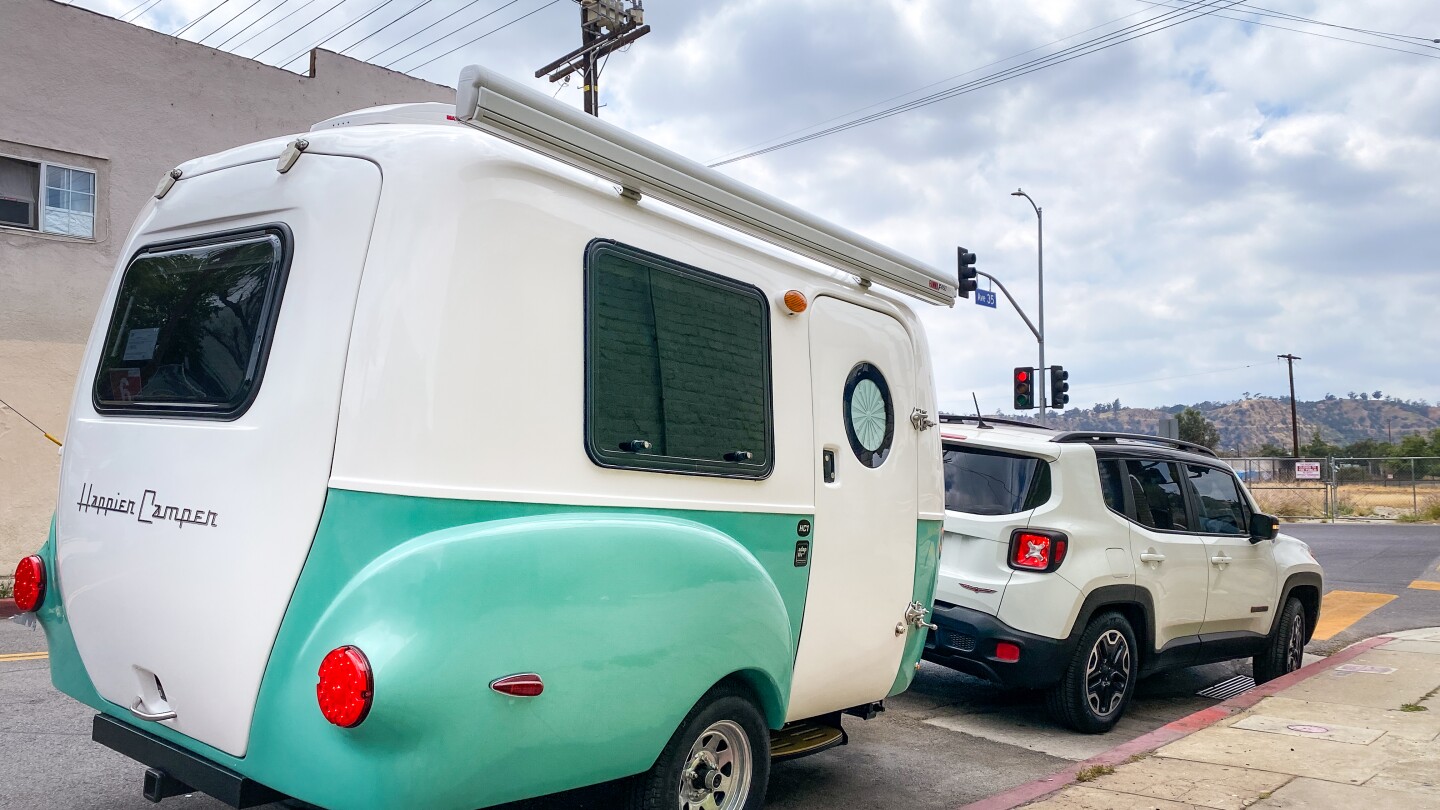 Pichardo's Mobile Art Lab, a teal and white trailer, is parked on the side of the road.