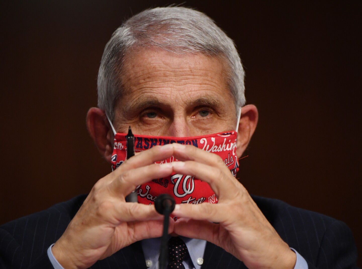 Dr. Anthony Fauci, director of the National Institute for Allergy and Infectious Diseases, prepares to testify at a hearing of the Senate Health, Education, Labor and Pensions Committee on June 30, 2020 in Washington, DC. He is wearing a red face mask with the word "Washington" on it.