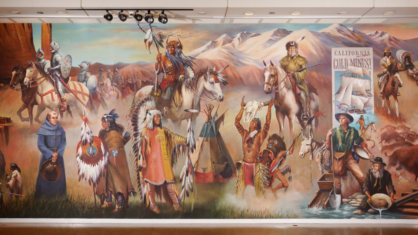 A mural painting depicts a collage of American West imagery, from cowboys and Native Americans to men on horseback and nods to Western films.